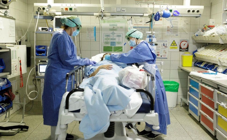 Dos sanitarios atienden a un paciente con coronavirus en el Hospital Universitario de Canarias. EFE