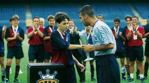 Pep Guardiola, como jugador del Barça, entrega a Iniesta la copa de la Nike Cup en 1999