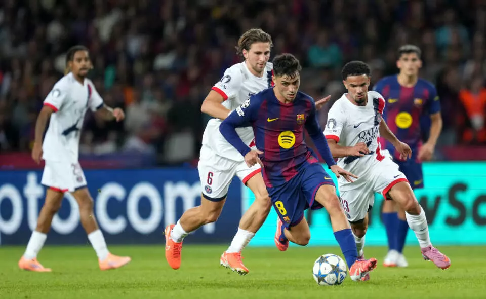 BARCELONA, SPAIN - OCTOBER 01: Pedri of FC Barcelona runs with the ball whilst under pressure from Illia Zabarnyi and Warren Zaire-Emery of Paris Saint-Germain during the UEFA Champions League 2025/26 League Phase MD2 match between FC Barcelona and Paris Saint-Germain at Estadi Olimpic Lluis Companys on October 01, 2025 in Barcelona, Spain. (Photo by Alex Caparros - UEFA/UEFA via Getty Images)