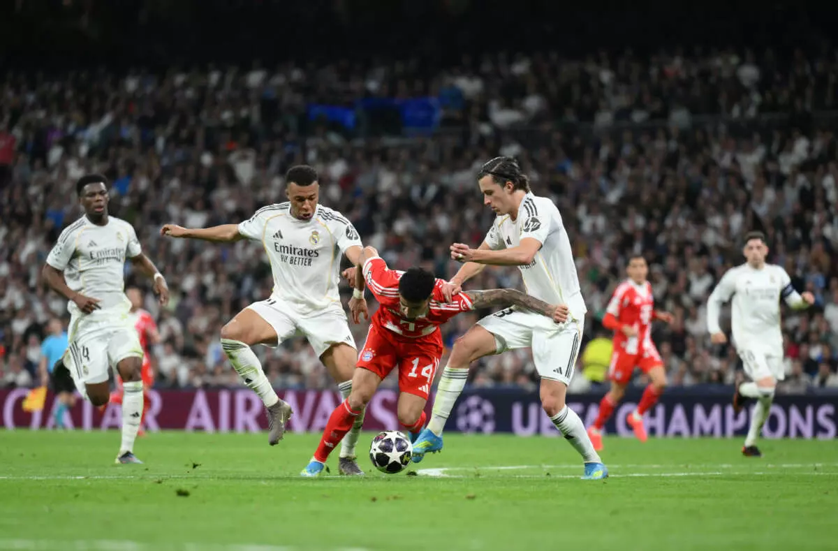 MADRID, SPAIN - APRIL 07: Luis Diaz of FC Bayern Munich is tackled by Alvaro Carreras and Kylian Mbappe of Real Madrid during the UEFA Champions League 2025/26 Quarter-Final First Leg match between Real Madrid CF and FC Bayern München at Estadio Santiago Bernabeu on April 07, 2026 in Madrid, Spain. (Photo by David Ramos - UEFA/UEFA via Getty Images)