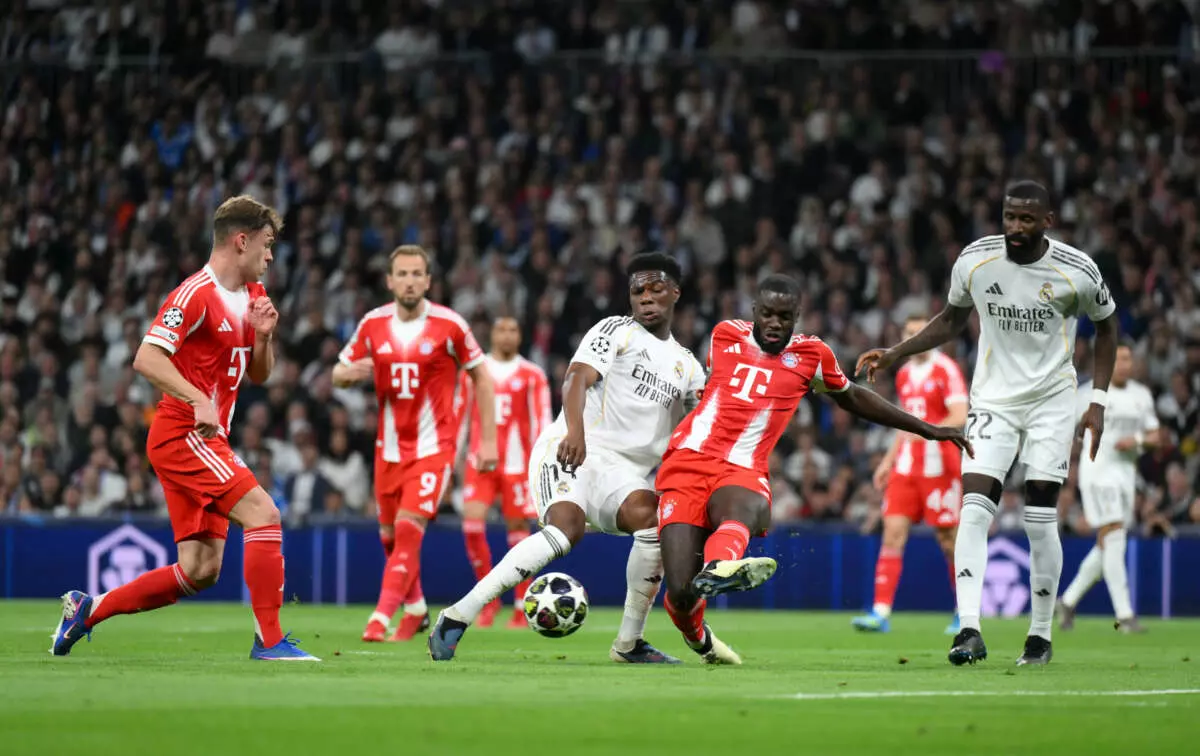 MADRID, SPAIN - APRIL 07: Dayot Upamecano of FC Bayern Munich passes the ball while under pressure from Aurelien Tchouameni of Real Madrid during the UEFA Champions League 2025/26 Quarter-Final First Leg match between Real Madrid CF and FC Bayern München at Estadio Santiago Bernabeu on April 07, 2026 in Madrid, Spain. (Photo by David Ramos - UEFA/UEFA via Getty Images)